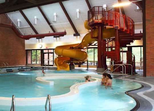 Mountain Park OR Apartments - MiLO at Mountain Park - Indoor Resort-Style Pool with Lap Swim Lanes, Recreational Swim Area, A Waterslide and a lot of Windows.
