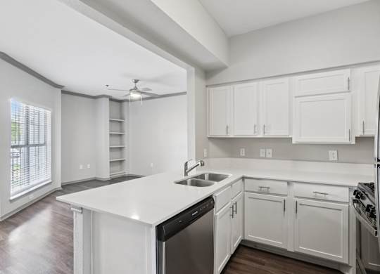 A modern kitchen with white cabinets and stainless steel appliances.