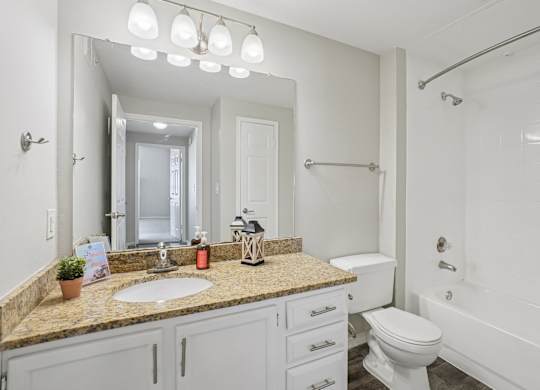 A bathroom with a sink, toilet, and bathtub.