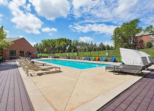 A large outdoor swimming pool surrounded by a wooden deck.