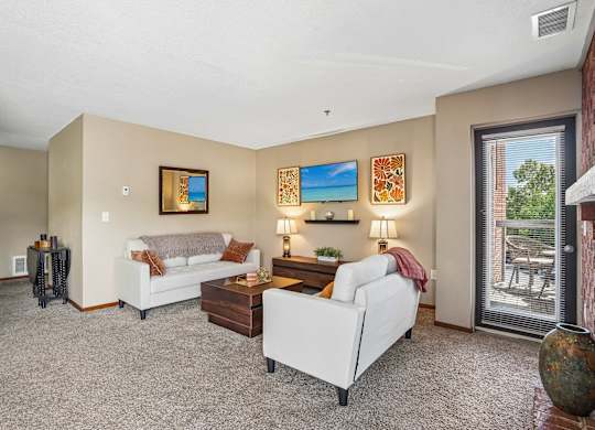 A living room with a white couch, a coffee table, and a painting on the wall.