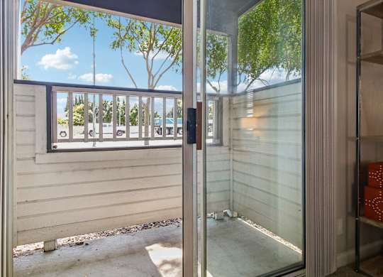 A view of a balcony through a glass door.