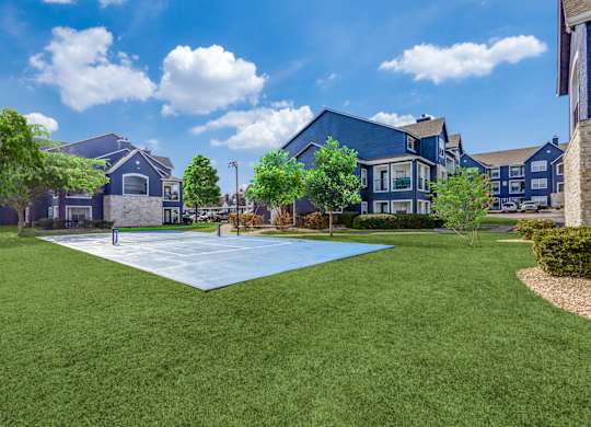 A large grassy area in front of a row of houses.