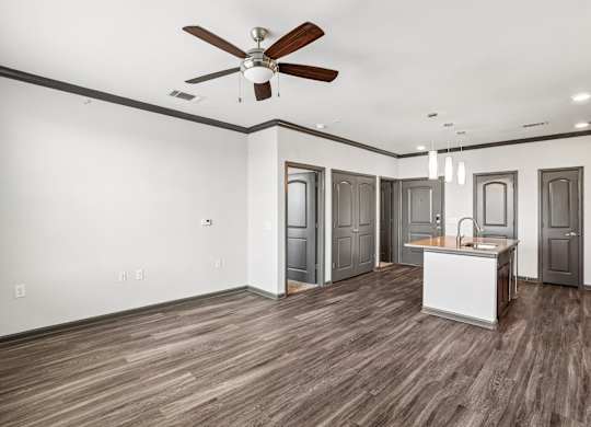 A room with a ceiling fan and wooden flooring.
