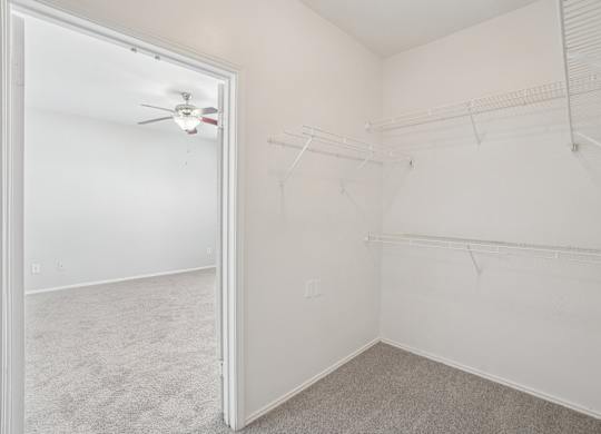 A white room with a ceiling fan and a door.