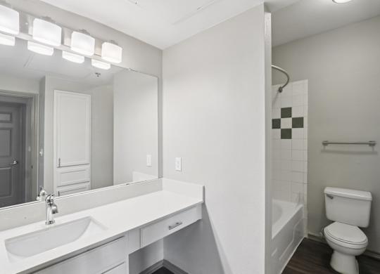 A white bathroom with a toilet, sink, and bathtub.