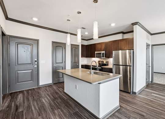 A modern kitchen with a white island and stainless steel appliances.