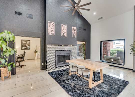A modern living room with a fireplace and a dining table.