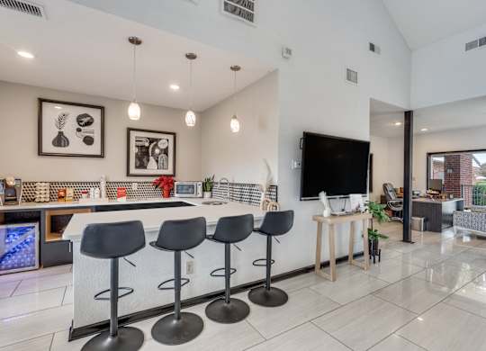 A modern kitchen with a bar area and a television.