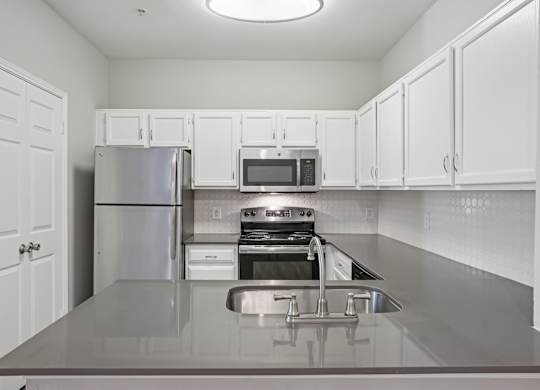 A kitchen with white cabinets and stainless steel appliances.
