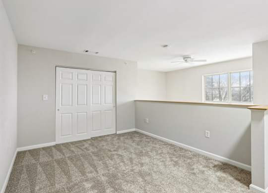A room with a white door and a carpeted floor.