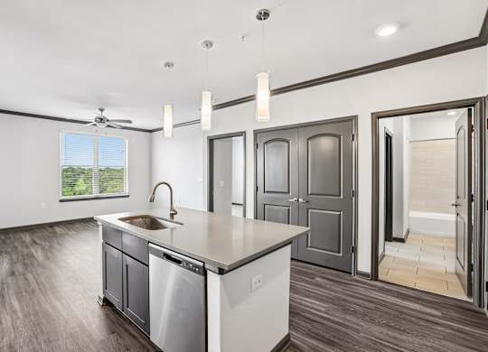 A modern kitchen with a large island and stainless steel appliances.