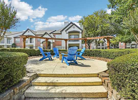 A building with a porch and blue chairs in front.
