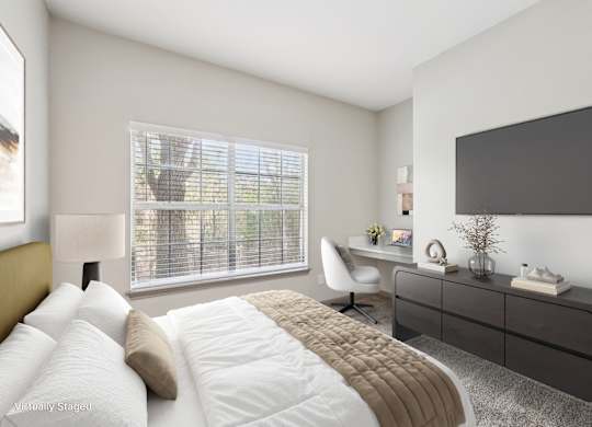 A modern bedroom with a large bed, a desk, and a window with blinds.