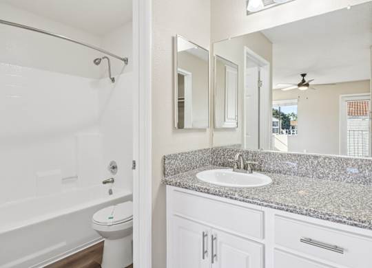 A bathroom with a sink, mirror, and toilet.