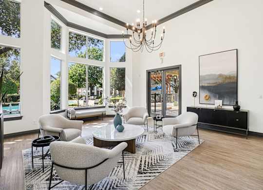 A living room with a large window and a chandelier.