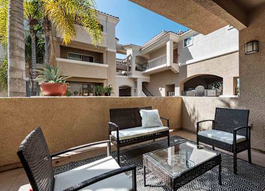 A patio with a table and chairs is in front of a building.