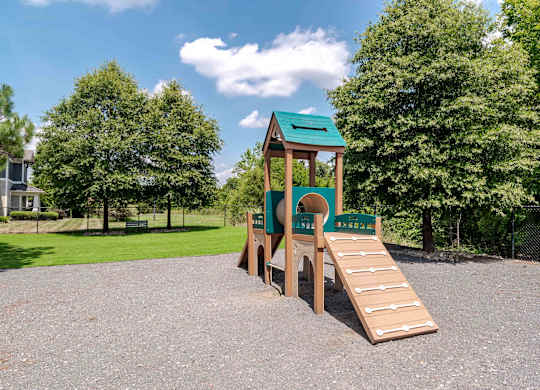 A playground with a green roof and a slide.