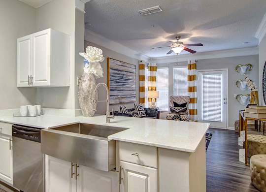 Pet-Friendly Apartments in Alpharetta, GA – The Ascent at Windward – view of living room from the kitchen with hardwood floors, ceiling fan and lots of light