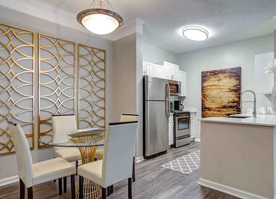 Alpharetta Apartments – The Ascent at Windward – dining room area with hardwood floors and view of kitchen