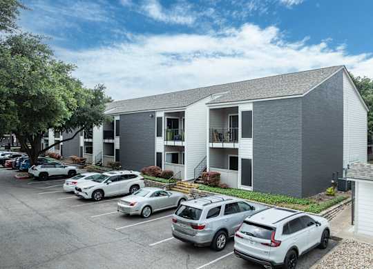 a gray building with cars parked in front of it