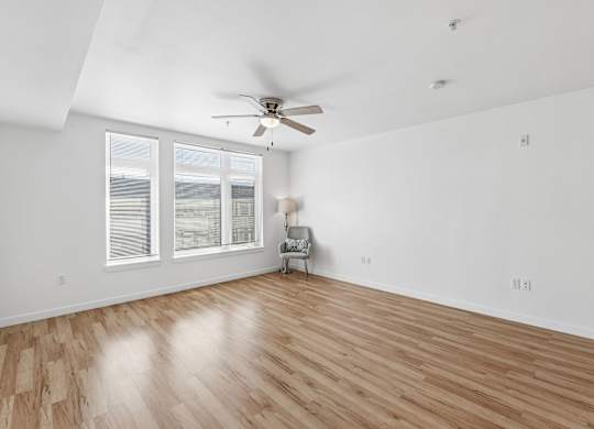 A room with a ceiling fan and a chair.