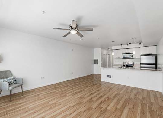 A room with a ceiling fan and a chair with a cushion on it.