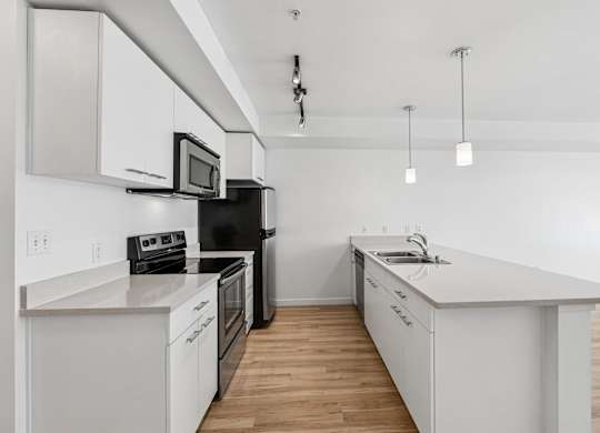 A modern kitchen with white cabinets and appliances.