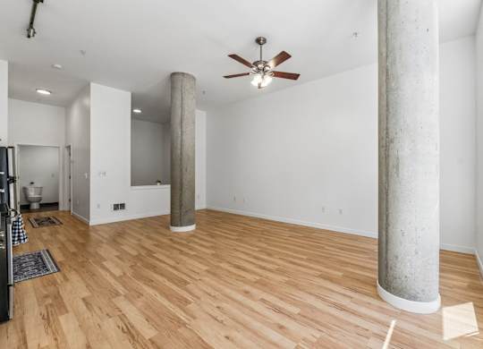 A room with wooden floors and a ceiling fan.