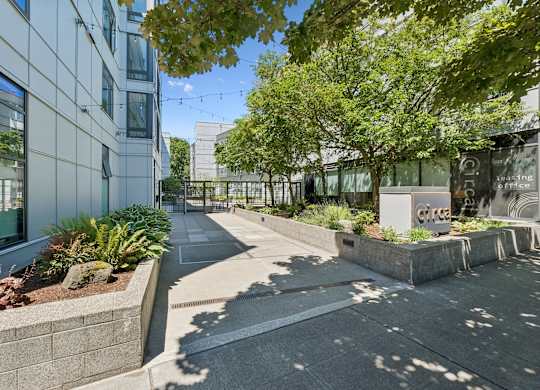 A modern building with a landscaped courtyard in front.