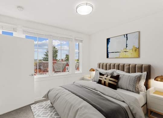 a bedroom with a bed and two windows