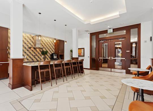 the lobby of a hotel with a bar and tables