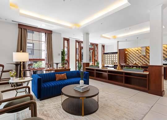 a lobby of a hotel with a blue couch and a coffee table