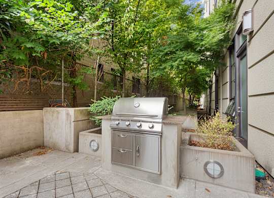 a backyard with a stainless steel grill on the side of a house