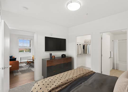a bedroom with a bed and a tv on the wall