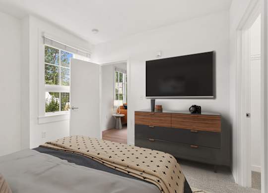 a bedroom with a bed and a television on the wall