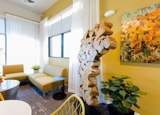 a living room with a tree sculpture in the corner