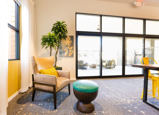 a living room with a chair and a table in front of a window