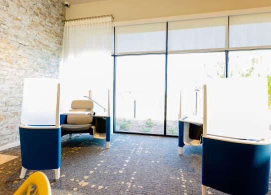 three tables with whiteboards in a room with large windows