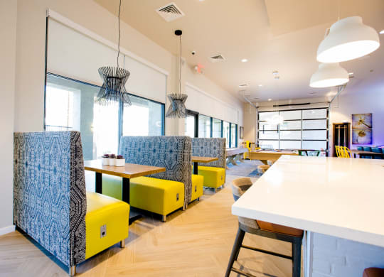 a seating area with yellow chairs and tables in a restaurant