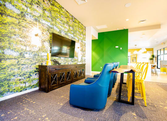 a lobby with blue chairs and a table and a television