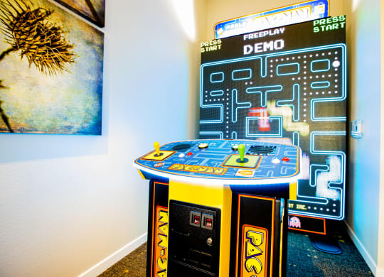 an arcade game in a room with a poster on the wall