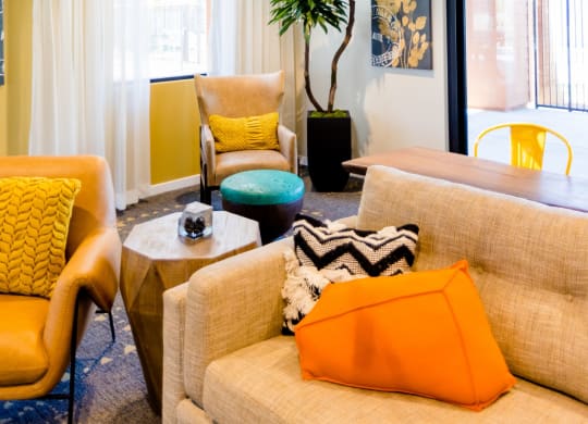 a living room with yellow walls and orange and blue furniture