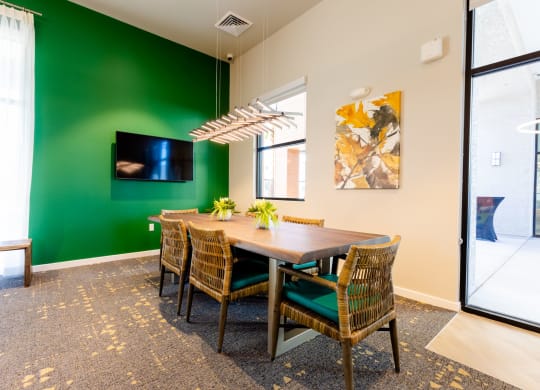 a dining room with a table and chairs and a green wall