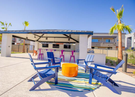 a patio with blue chairs and a table and a canopy