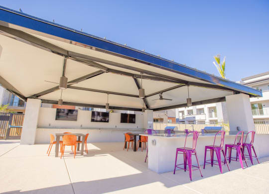 a patio with chairs and a bar and a roof