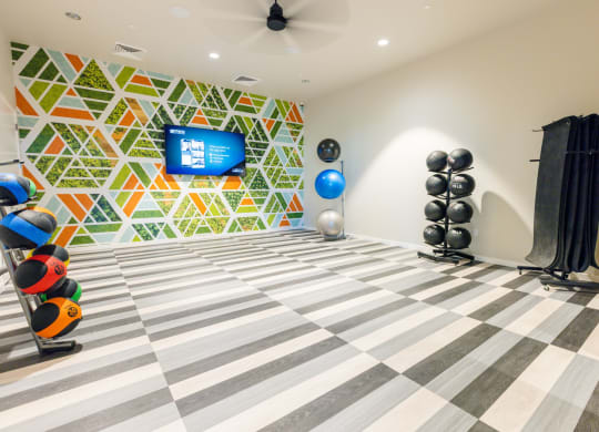 a gym with a checkered floor and a wall with a television
