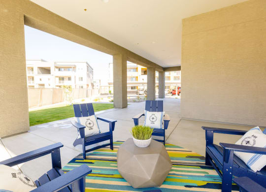 the lobby of a hotel with blue chairs and a colorful rug