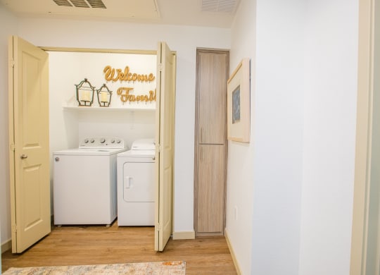 a laundry room with a washer and dryer and a sign on the wall