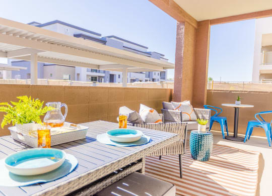 a furnished patio with a dining table and chairs